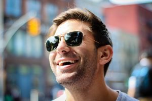 man smiling while wearing sunglasses