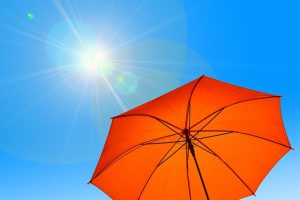 orange parasol under sun and blue sky